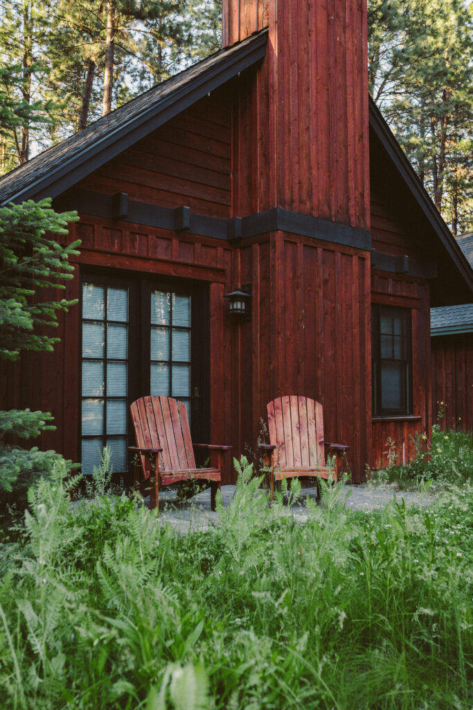 Exterior view of cabin with 2 Adirondack chairs on a patio