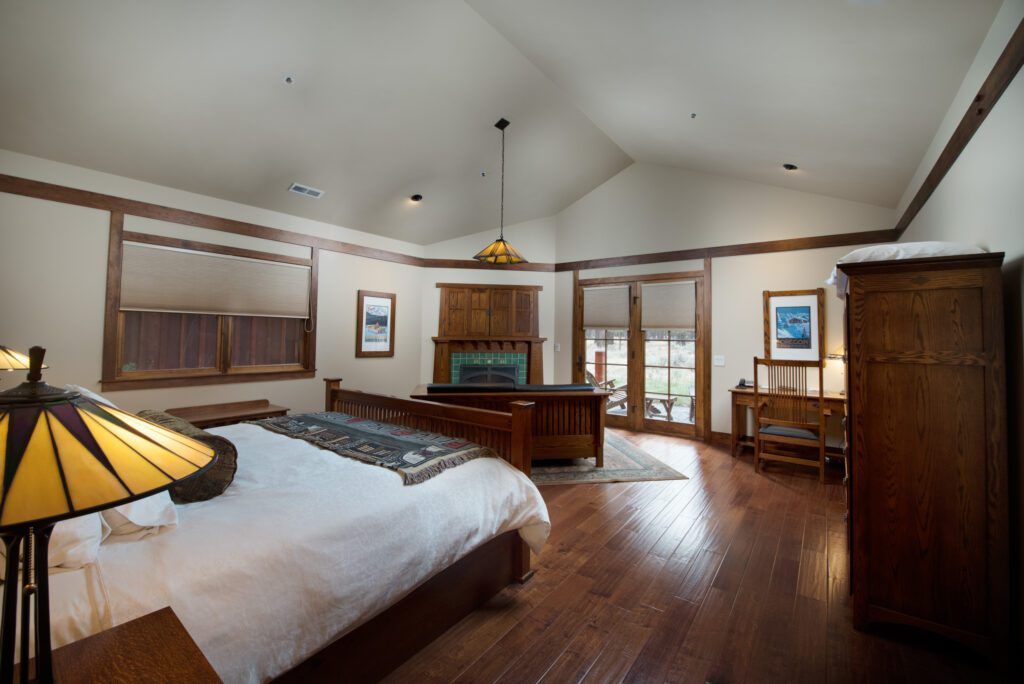 Interior of a cabin with bed, desk and fireplace