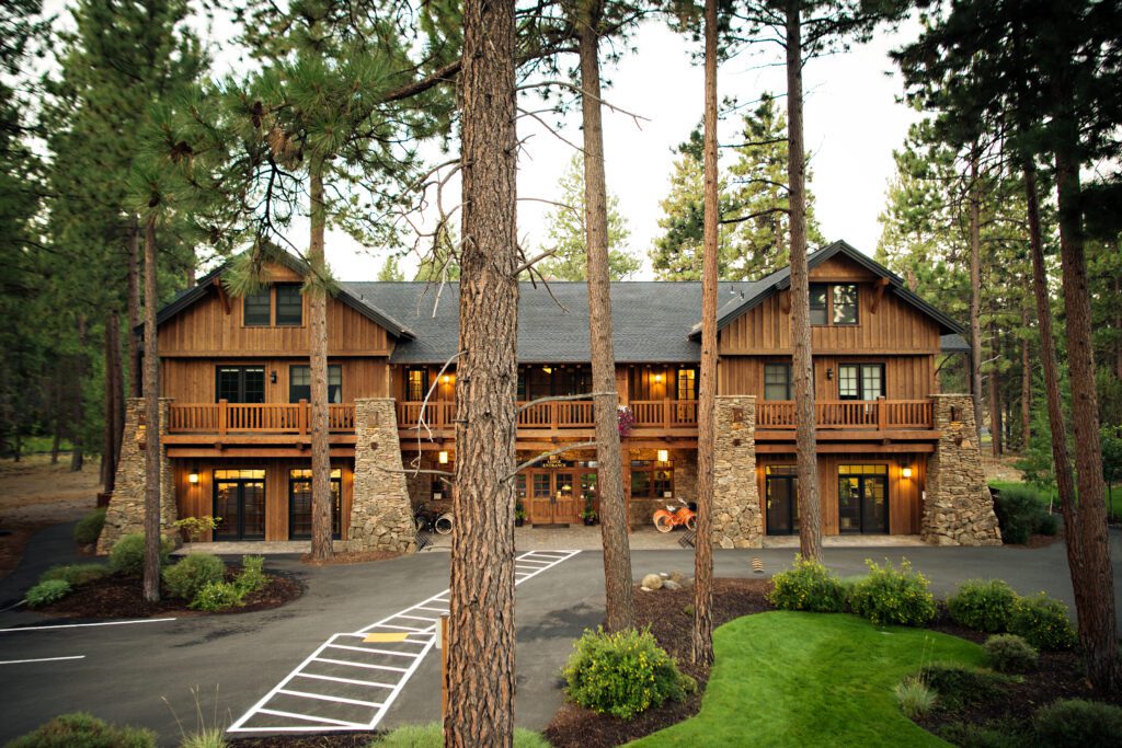 Exterior view of wooden lodge with pine trees in the foreground