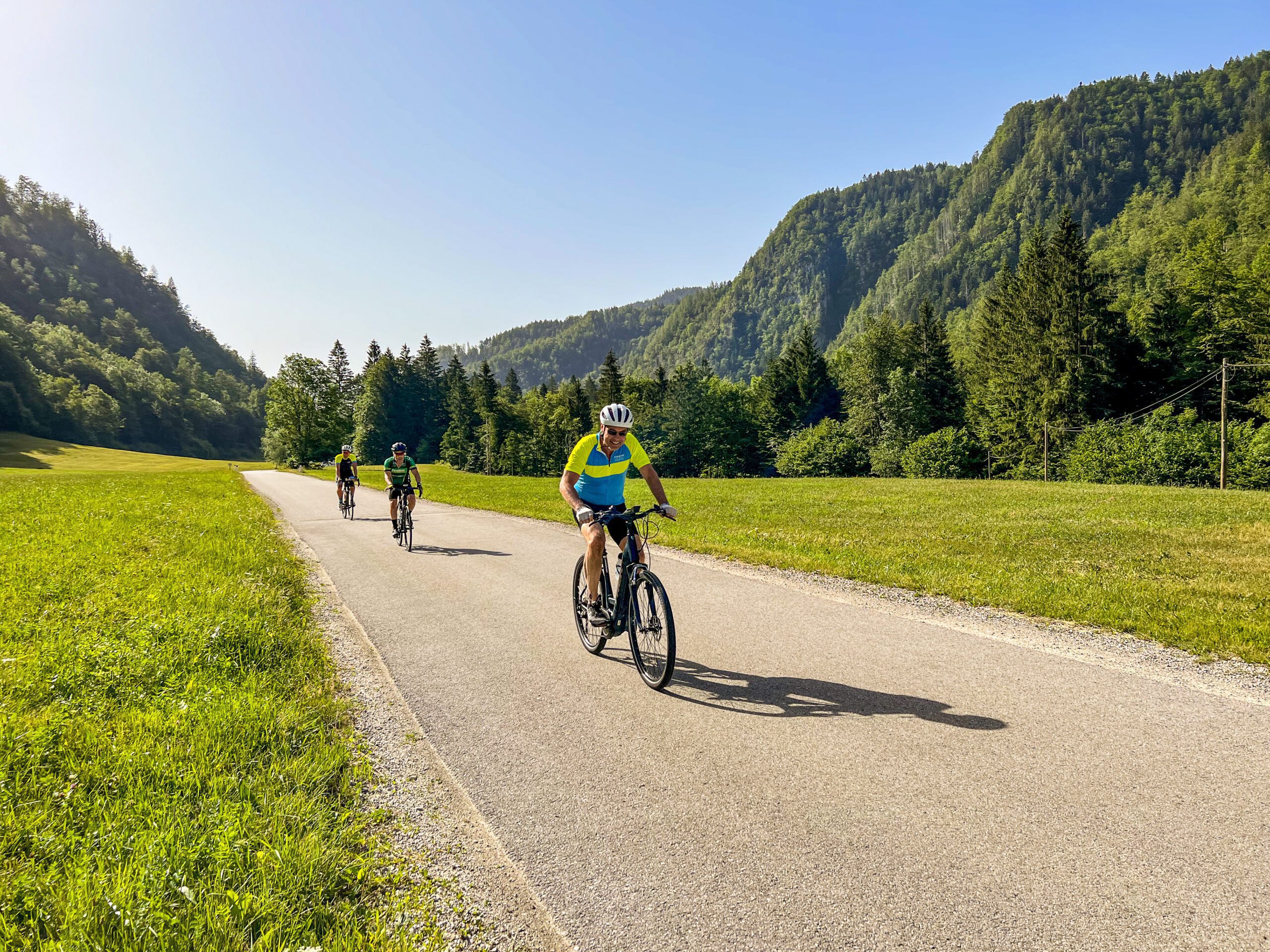 3 cyclists riding their bikes on a paved road in Slovenia