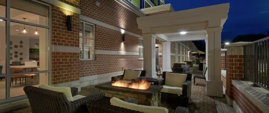 Outdoor patio with a lit fire table at Hilton Garden Inn Corning