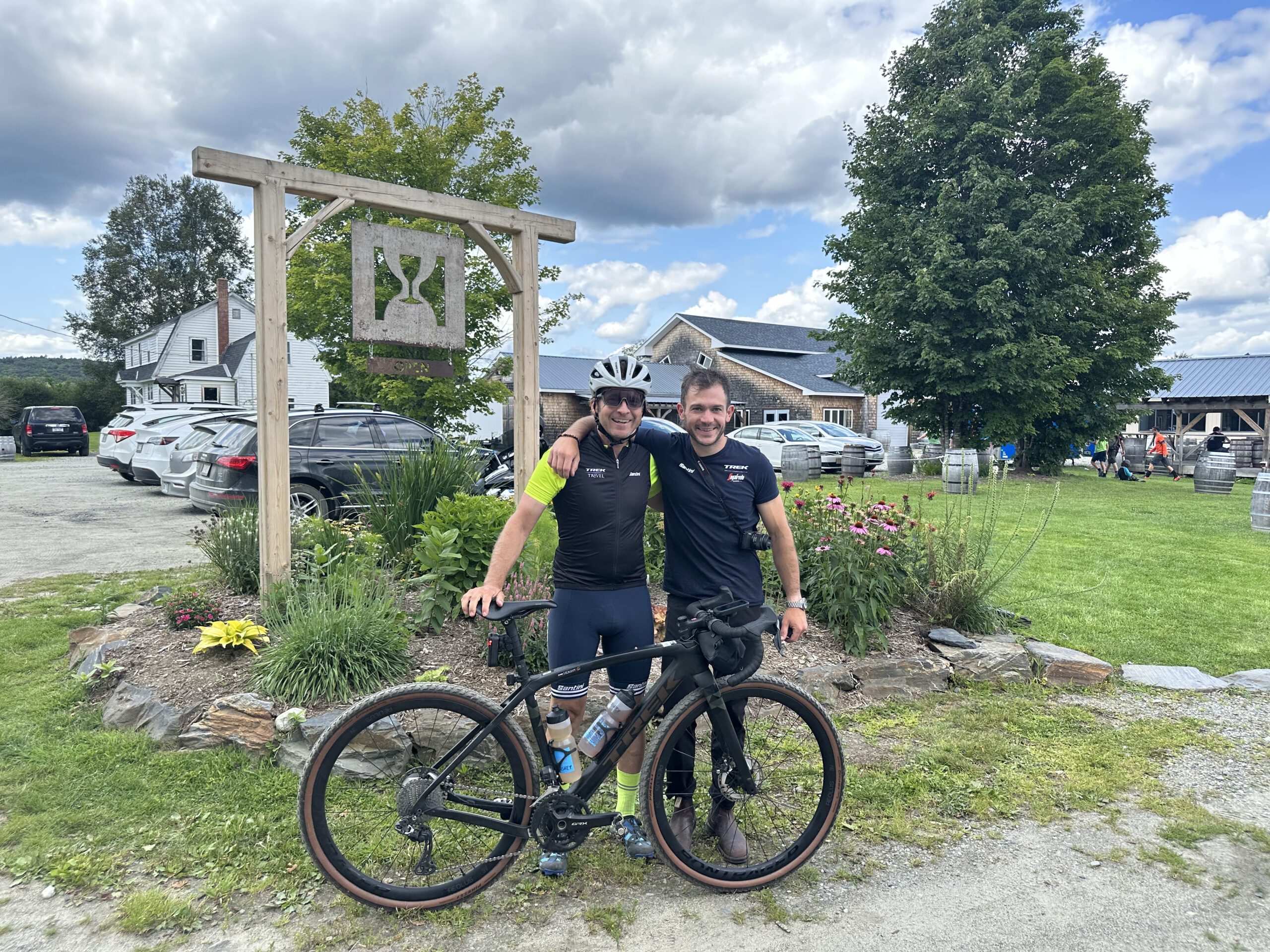 Two cyclists standing in front of Hill Farmstead Brewery sign