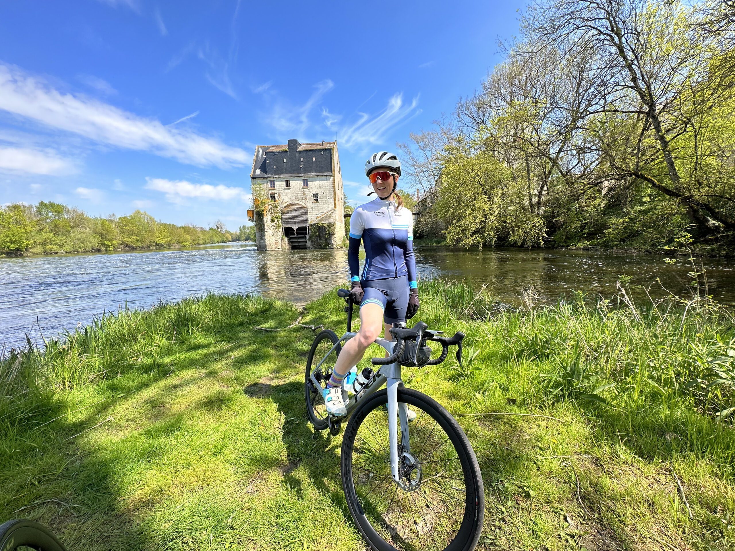 a cyclist posing next to the loire river