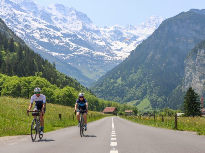 2 cyclists with snowy mountains