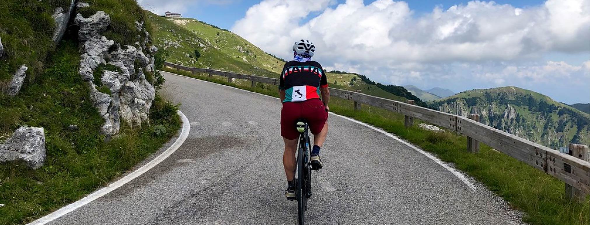 Cyclist in an Italy jersey on a scenic climb.