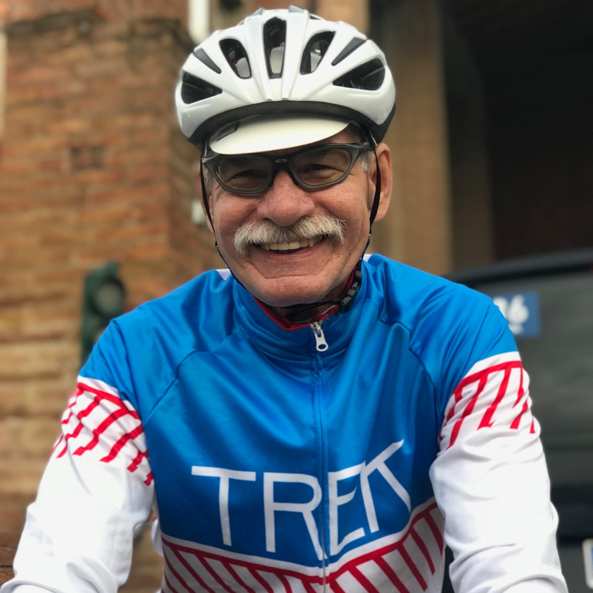 Close-up portrait of cyclist smiling, wearing Trek jersey.