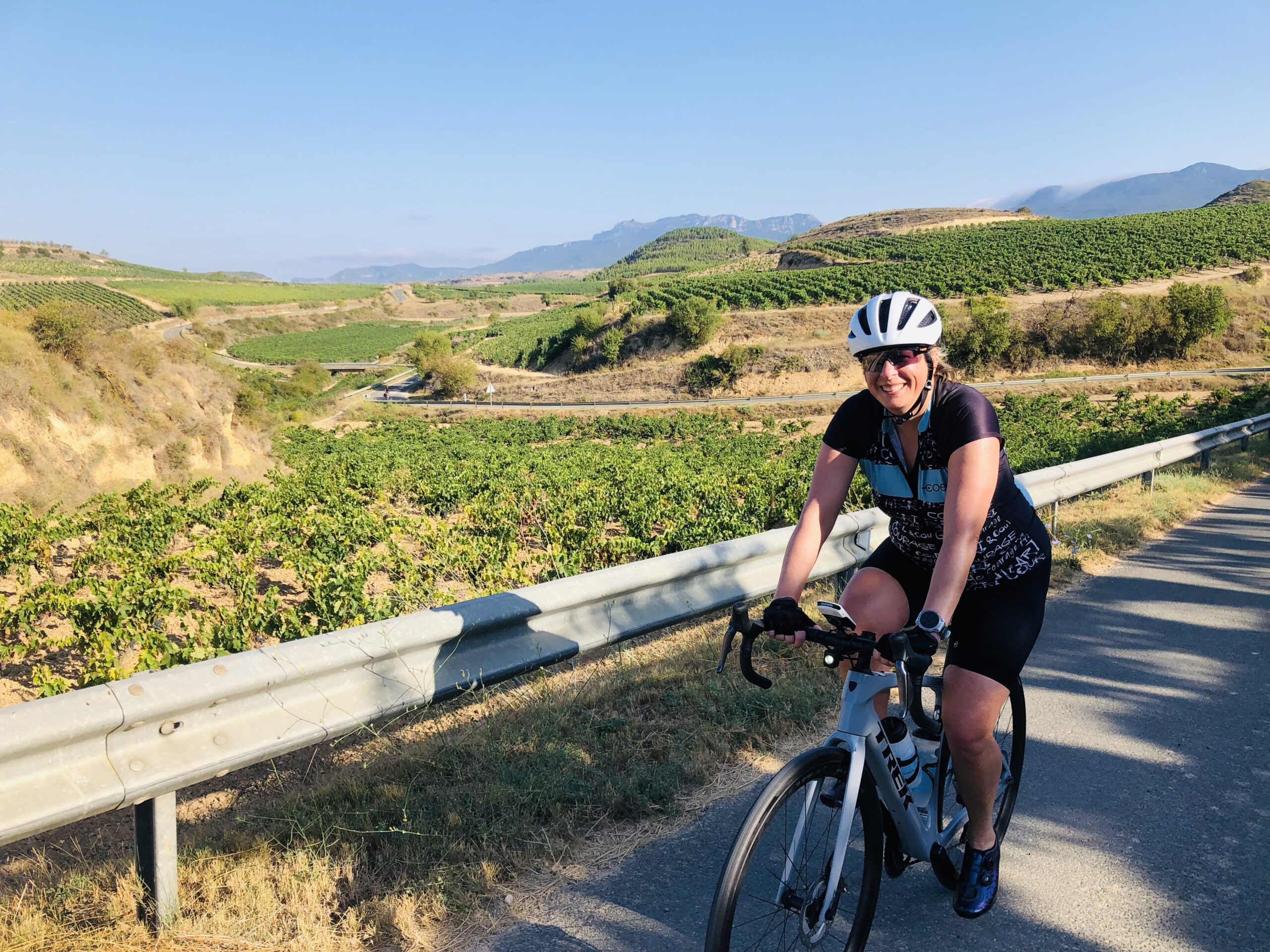 Woman riding with vineyards in the background below her