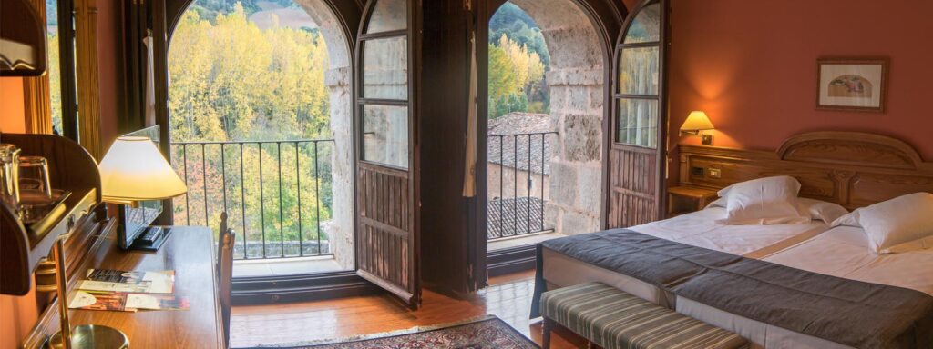 Double bedroom with large double doors to balcony at Hotel San Millan