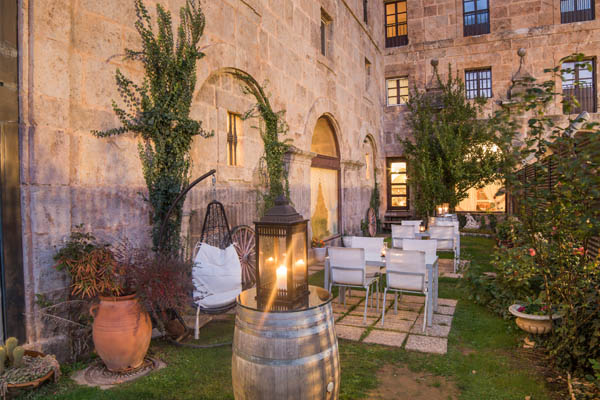Outdoor patio with tables, chairs and lanterns at Hotel San Millan