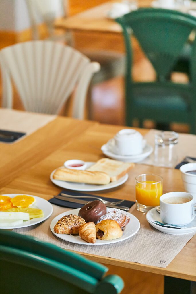 Hotel breakfast plate with orange juice, croissants, and coffee