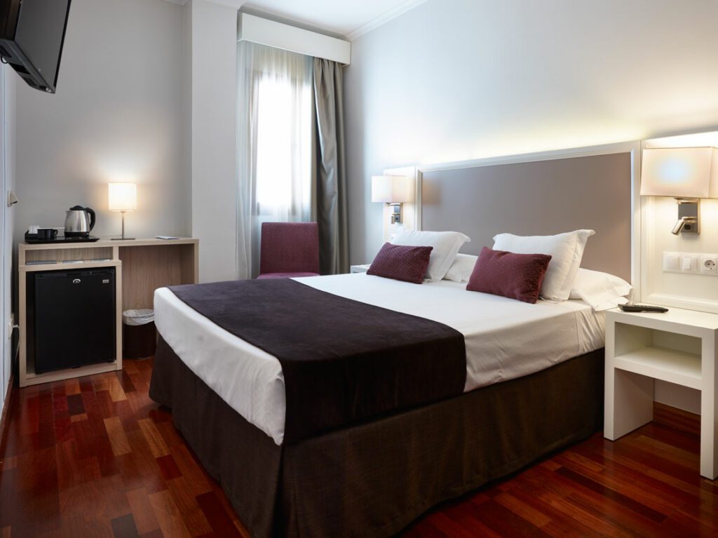 Hotel room with double bed and wood flooring