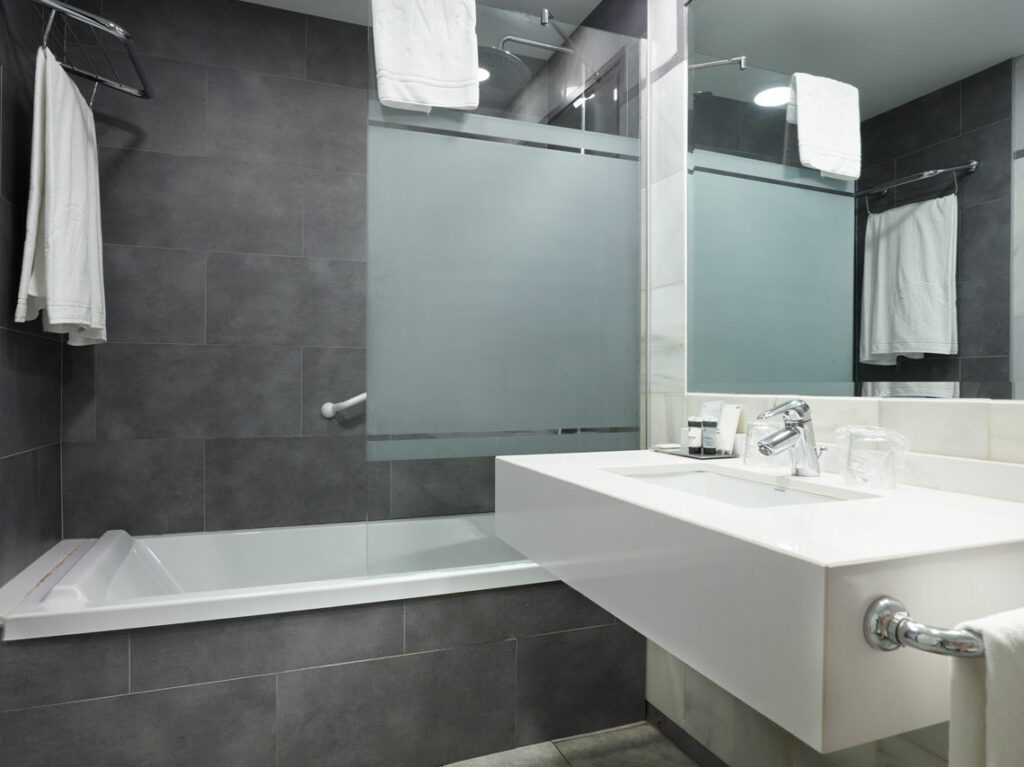 Bathroom tub and sink at Hotel Maestranza