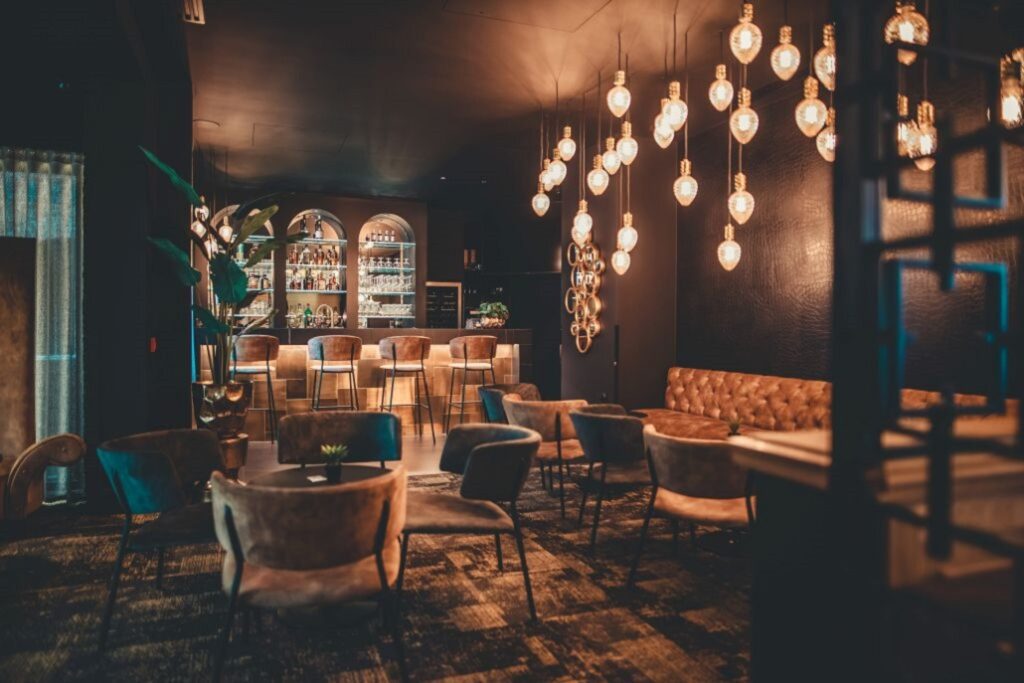 Bar with dark interiors and pendant lighting at Dukes' Academie hotel