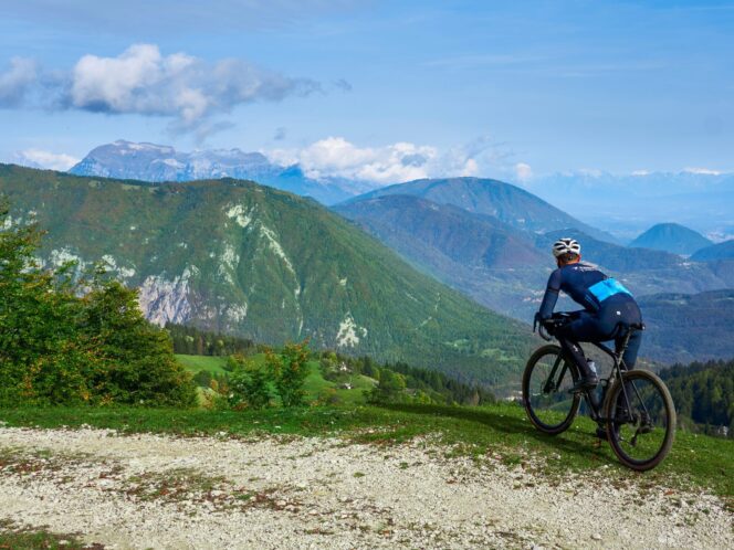 Cyclist overlooking the valley and mountains from a gravel road