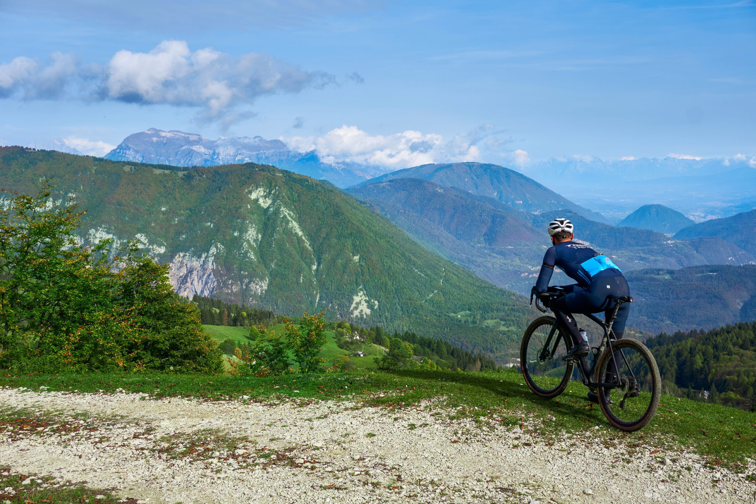 Cyclist overlooking the valley and mountains from a gravel road