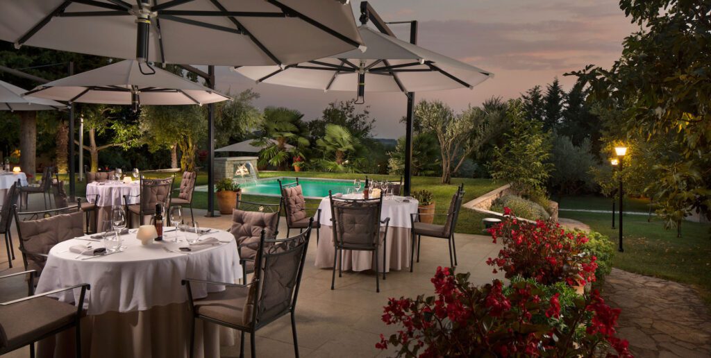 Evening view of dining patio and pool in the garden of Hotel San Rocco