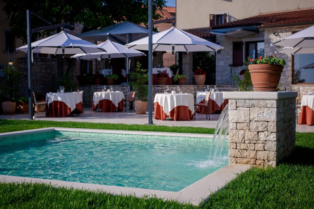 Outdoor patio and pool with water fountain at Hotel San Rocco