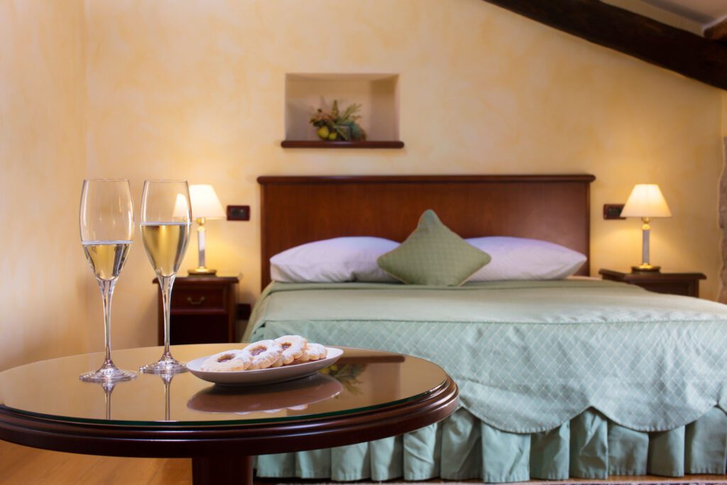 Double bed and champagne glasses at Hotel San Rocco
