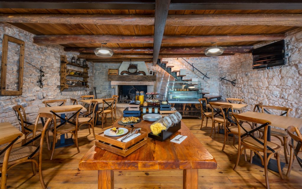 Dining area with stone walls and wood beam ceiling at Hotel San Tommaso