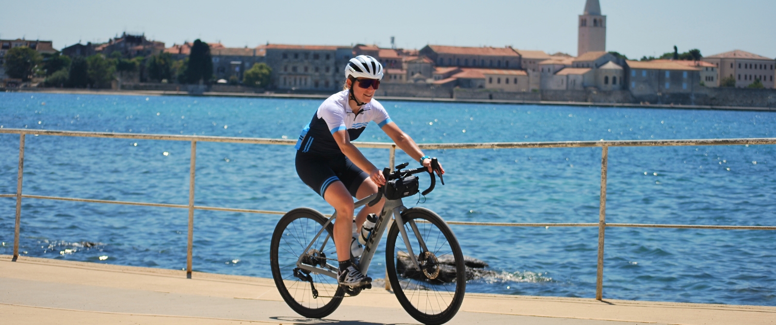 A cyclist riding alongside the sea