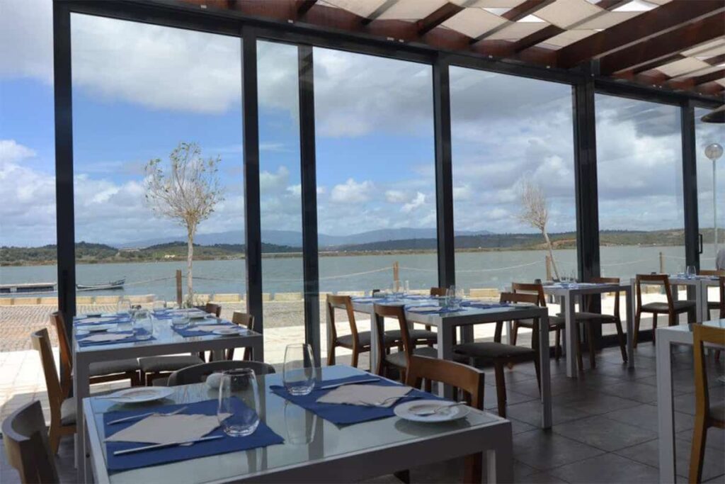 Indoor and outdoor dining area with large windows at Agua Hotel and Spa Resort