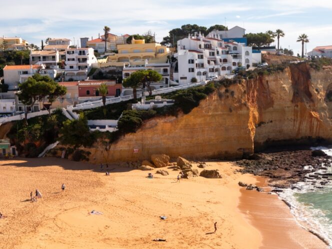 A town on a sloping cliff with a beach