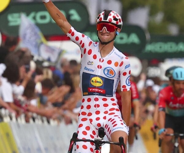 Lidl-Trek pro racer in polka dot jersey with arm raised in celebration