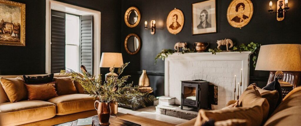 A hotel lounge area with a fireplace, sofa, and black and gold decor