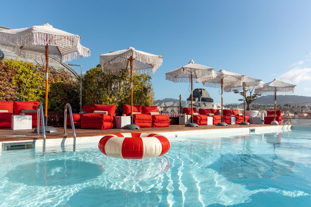 Pool with bar club chairs and macrame umbrellas at Hotel Boscolo in Nice