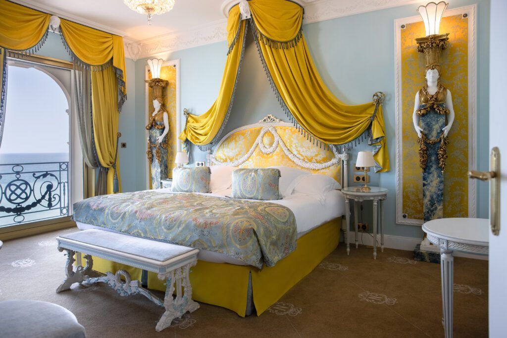 Ornate double hotel bedroom with sea view
