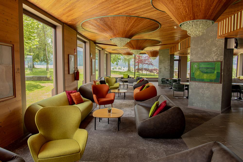 Lounge area with large windows and decorative wooden ceiling at Linta Hotel Wellness & Spa