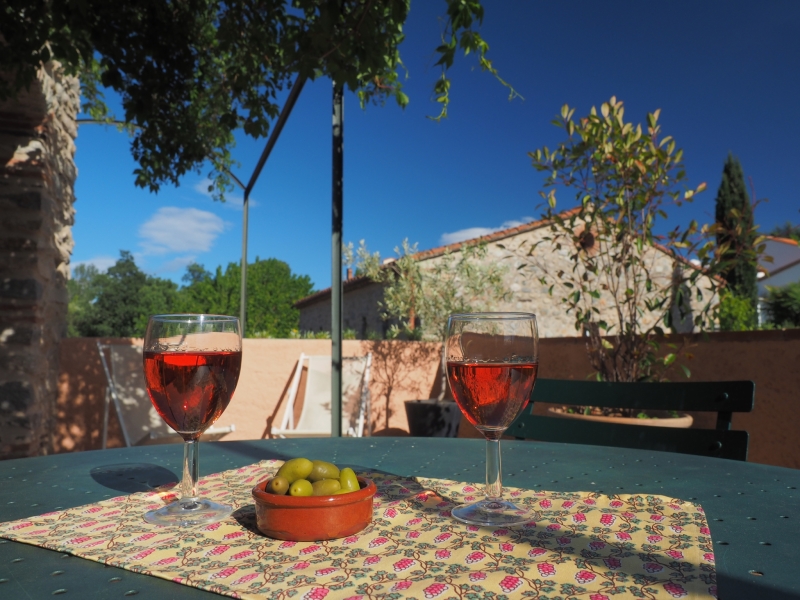 Table with two glasses of rose wine and olives at Mas de Trilles