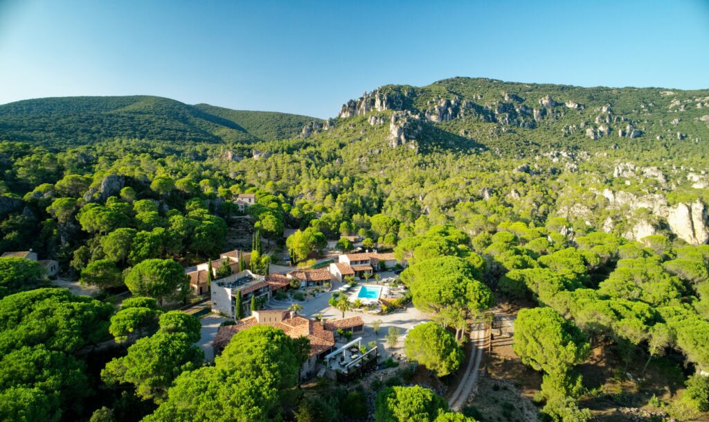 Aerial view of Auberge de Mourèze set in the hills surrounded by forest