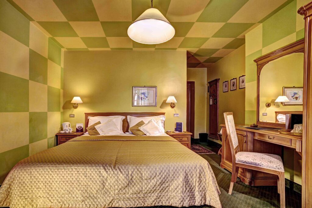 Double room with decorative checkered walls and ceiling at Storico Hotel Regina