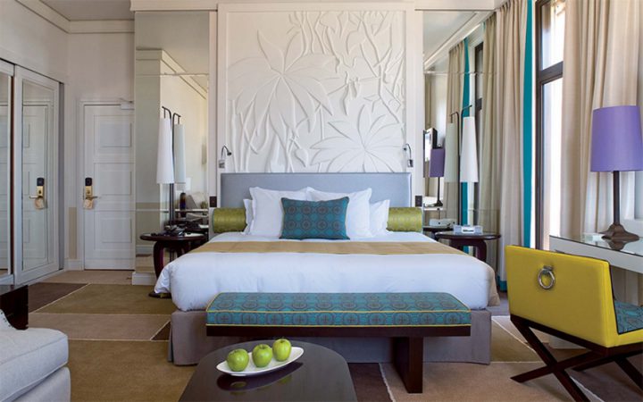 Double hotel bedroom with mirrors, side table and three apples at the Royal Riviera