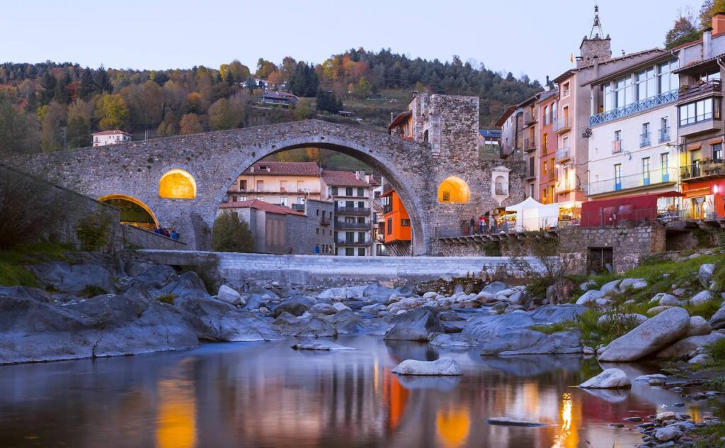 Old stone bridge and buildings along a river in Camprodon