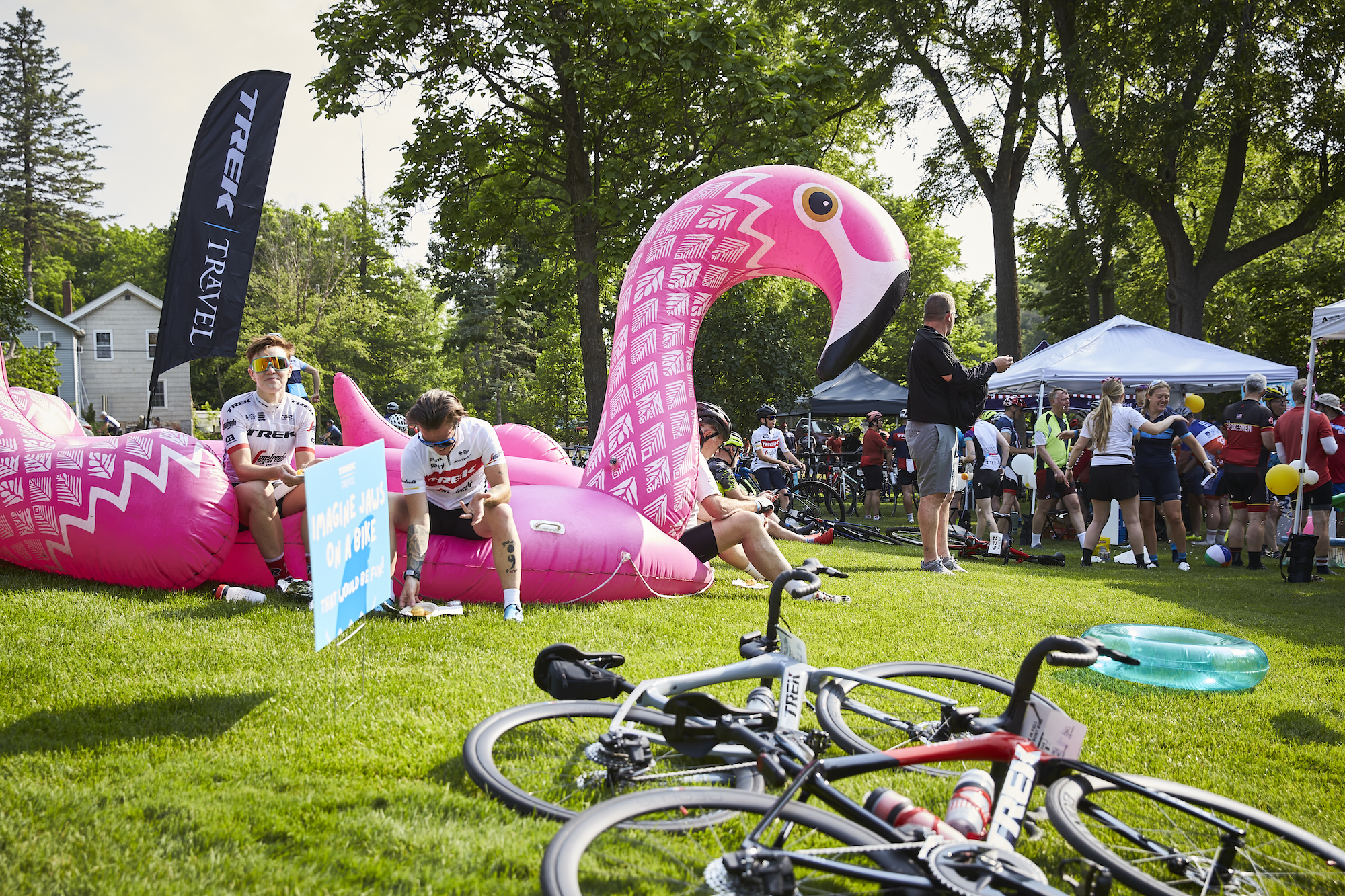 Large groups of people gathering at the Trek 100 with a large inflatable flamingo