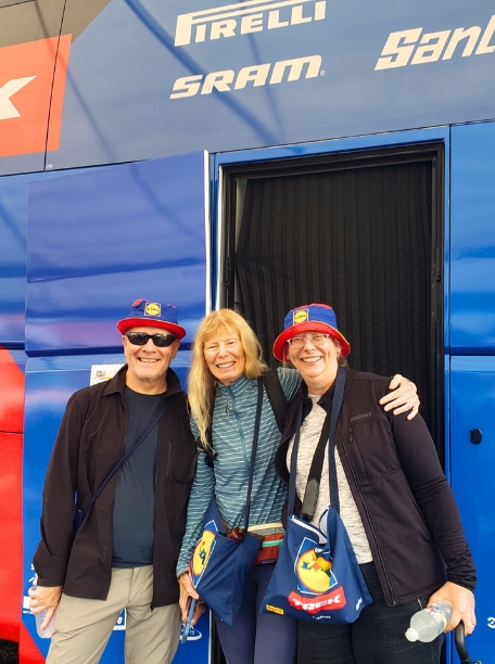 Three people in front of the Lidl-Trek team bus
