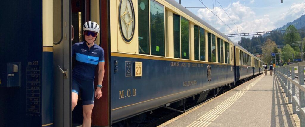 Image of a Swiss train with a Trek Travel guide in the doorway.