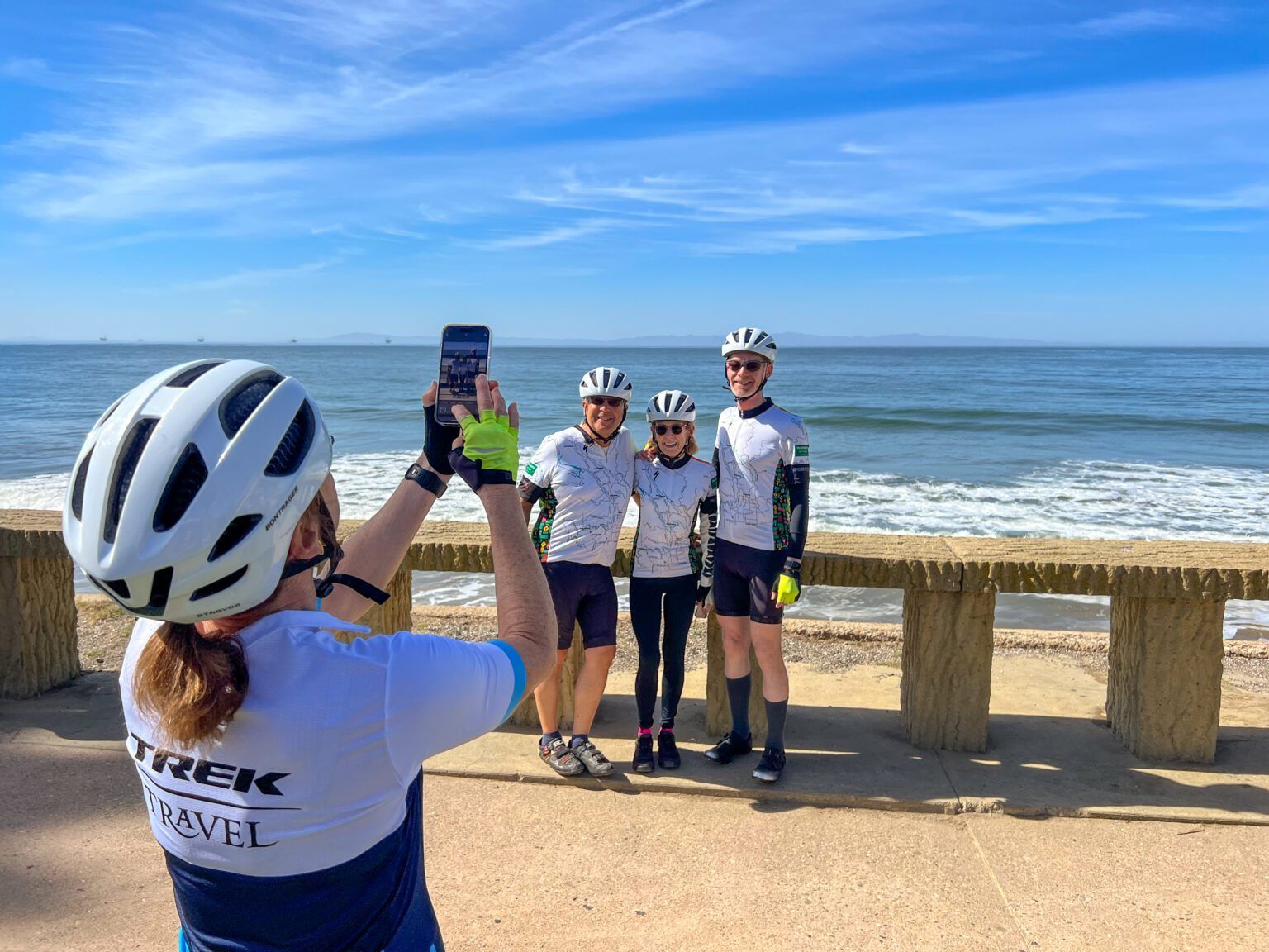 A person taking a picture of three people on the beach