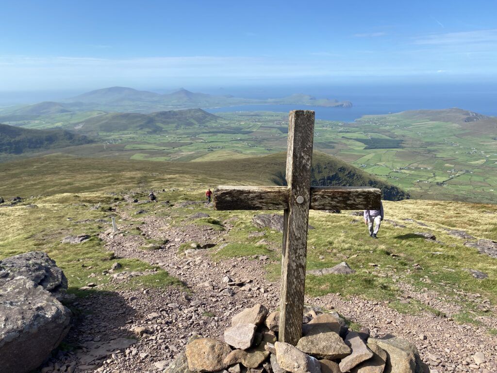 A wooden cross on top of Mount Brandon, with ocean views