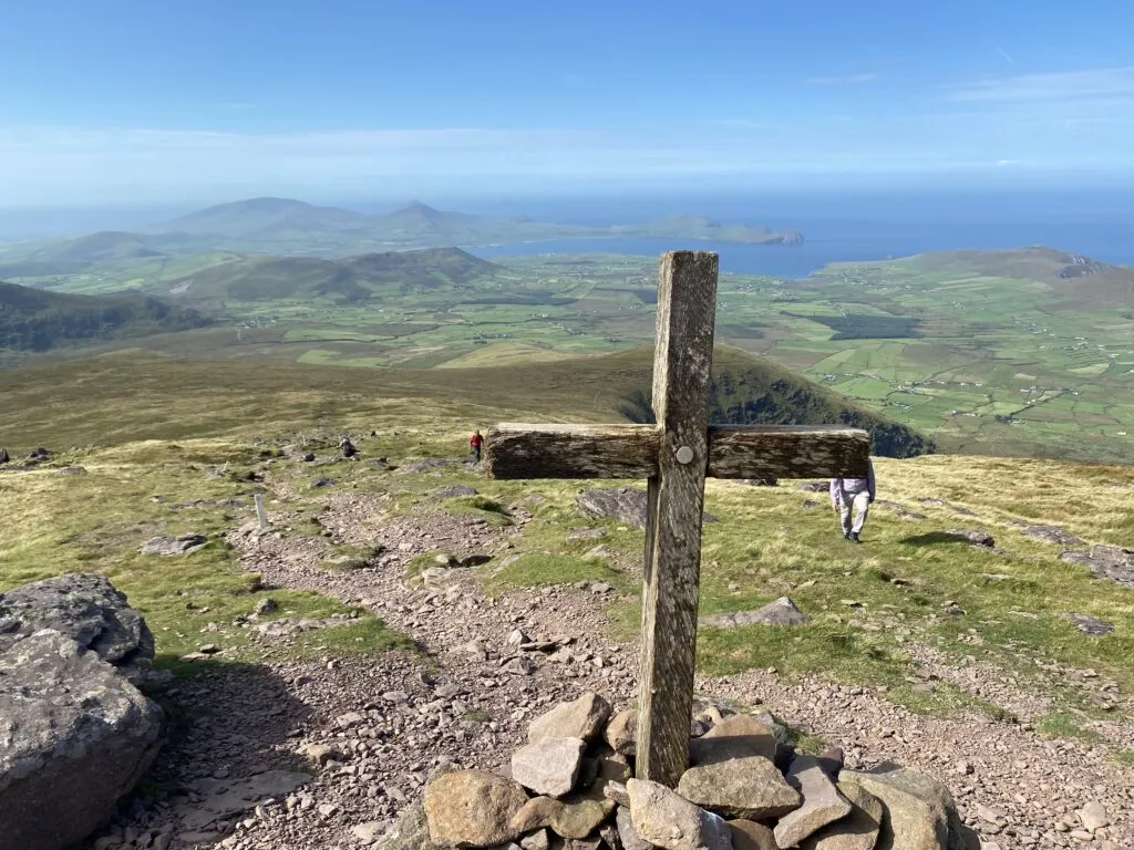 A wooden cross on top of Mount Brandon, with ocean views