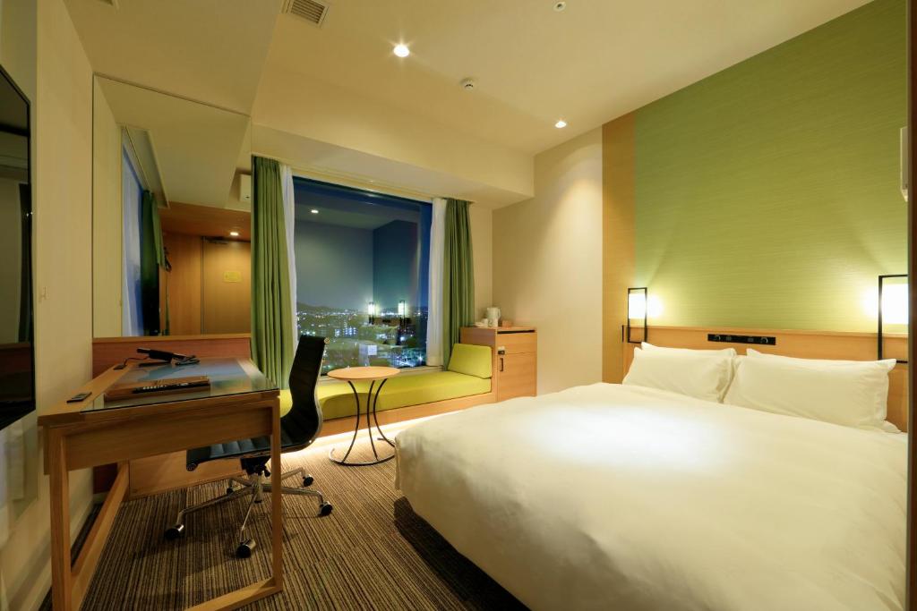 Double bedroom with large window at Candeo Nara Kashihara hotel.