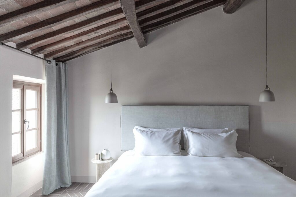 Double bed room with wooden rafter ceiling at Pieve Aldina
